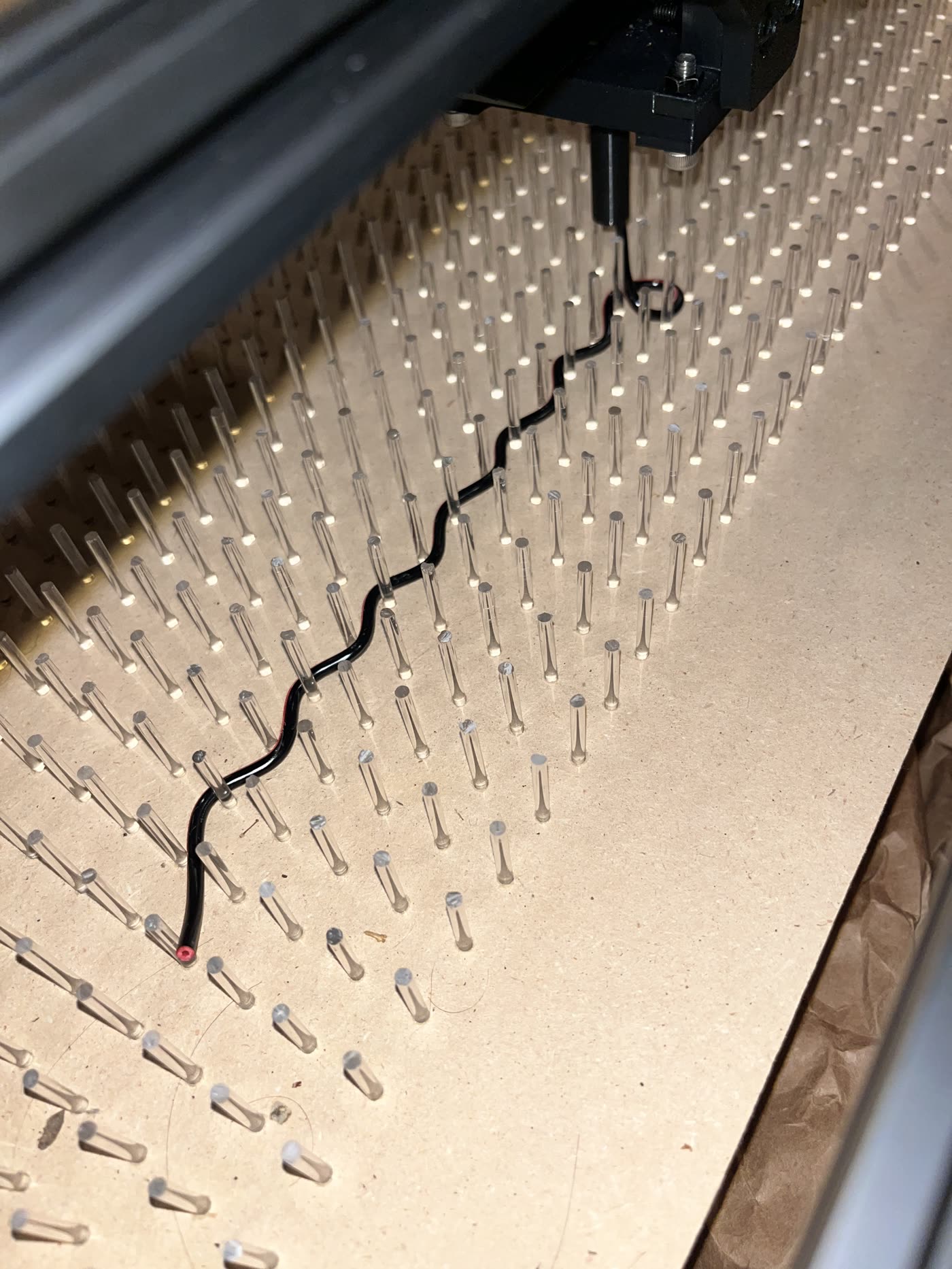 Close-up of extruded wire routed between pegs